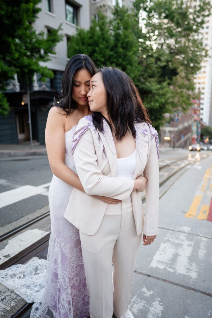 Queer lesbian brides in city of San Francisco, one bride wearing Claire Pettibone gown.