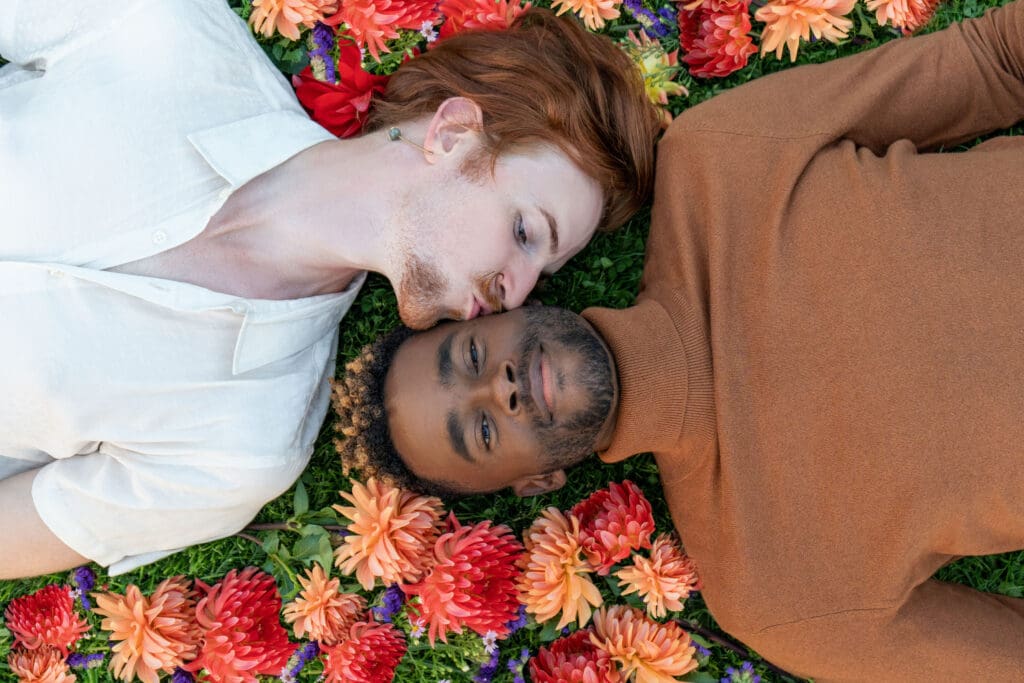 Queer couple engagement shoot laying in Seattle flower fields