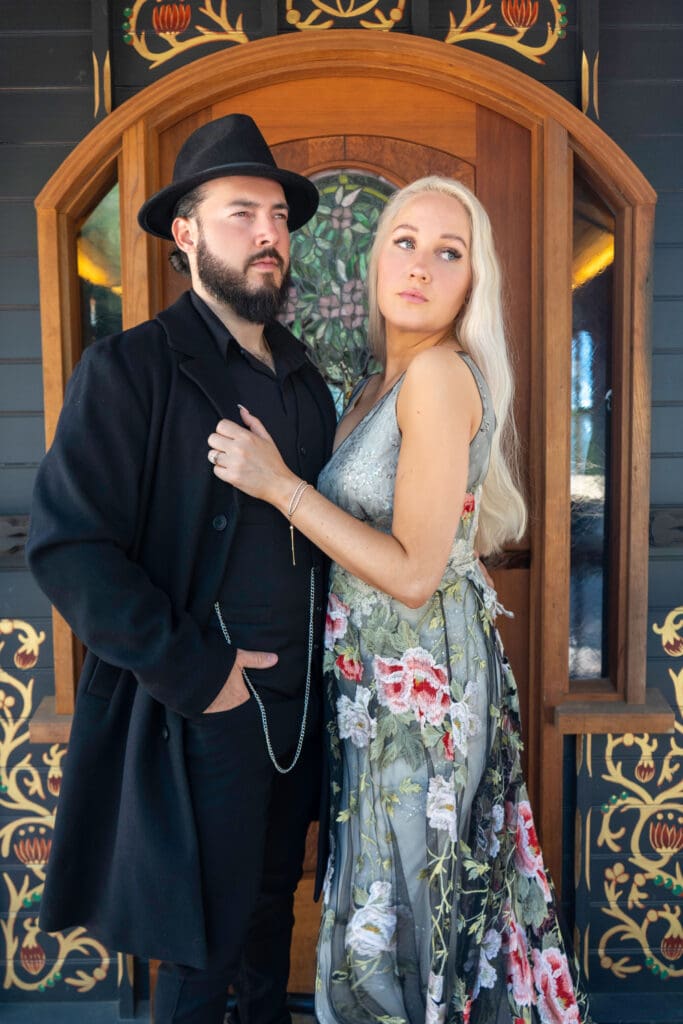Peaky Blinders inspired engagement shoot closeup shot of the bride wearing the Raven gown from Claire Pettibone and groom in front of a Malibu mountain gypsy caravan