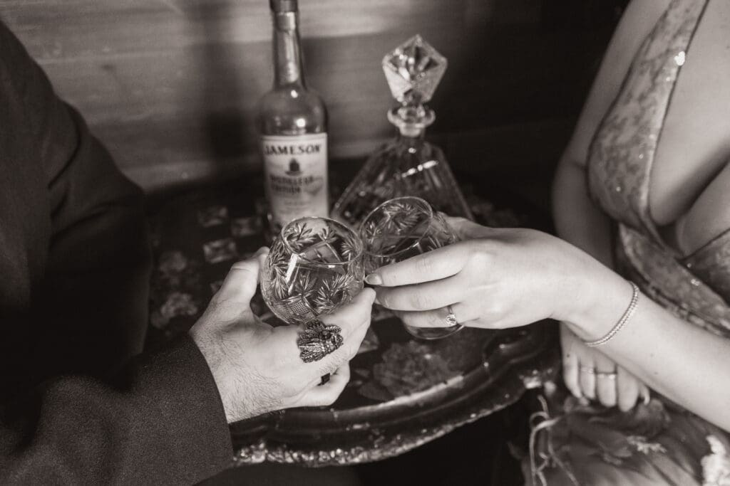 Bride and groom closeup detail of whiskey glasses and bottle of Jameson