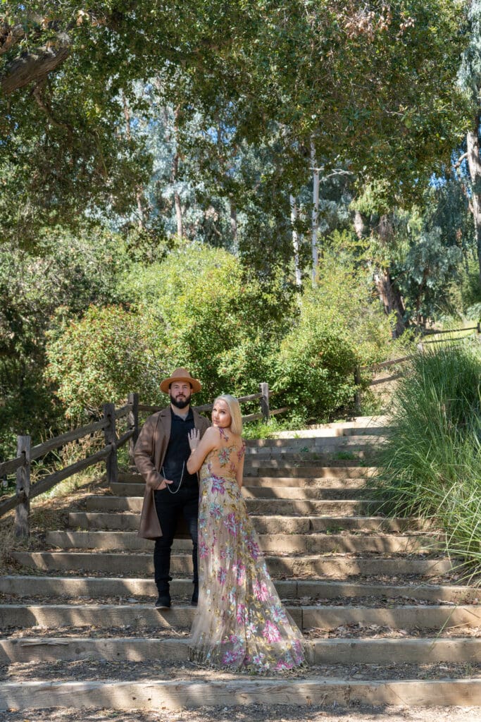 Bride and groom engagement shoot in Malibu mountains with the groom wearing cowboy attire and the bride the Shangri-La gown by Claire Pettibone