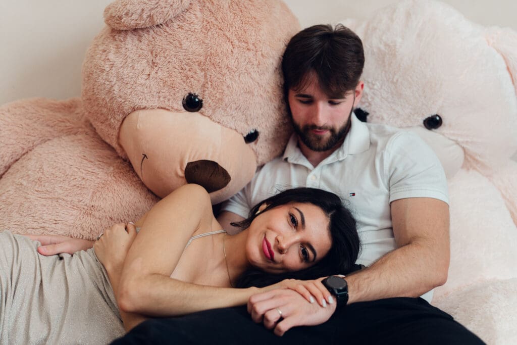 Woman resting her head on partner’s lap surrounded by oversized teddy bears during romantic Valentine’s Day photoshoot at LA Loft Studios in Los Angeles.
