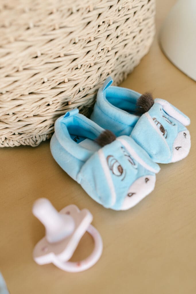 Baby shoes and a pacifier photographed during an in-home lifestyle newborn photography session in Camarillo.